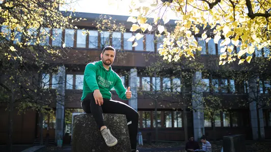 Person sitzt im Herbst vor der Bibliothek in der Feldkirchenstra?e.