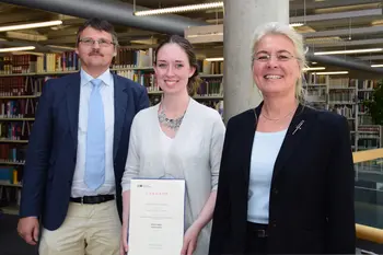 Die Auszubildende der Universit?tsbibliothek Leoni Schmalz, Beste ihres Jahrgangs, mit ihrer Urkunde vor einem Bcherregal in der Teilbibliothek 4. Links neben ihr Bibliotheksdirektor Dr. Fabian Franke, rechts neben ihr Kanzlerin Dr. Dagmar Steuer-Flieser. 